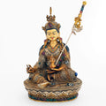 Padmasambhava (Guru Rinpoche) Statue, Körper aus Kupfer gegossen, verziert mit filigranen Ornamenten, versilbert und vergoldet, besetzt mit bunten Steinen. Das Gesicht ist in Gold gefasst.