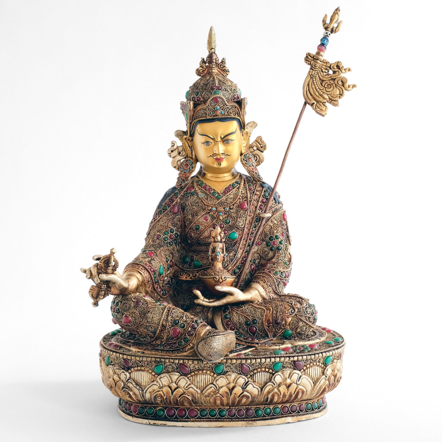 Padmasambhava (Guru Rinpoche) Statue, Körper aus Kupfer gegossen, sein königliches Gewand ist mit Filigran Ornamenten verziert, versilbert und vergoldet, mit farbigen Steinen besetzt. Das Gesicht ist in Gold gefasst. Er hält eine Schädelschale mit einer Amrita Vase in seiner linken Hand.