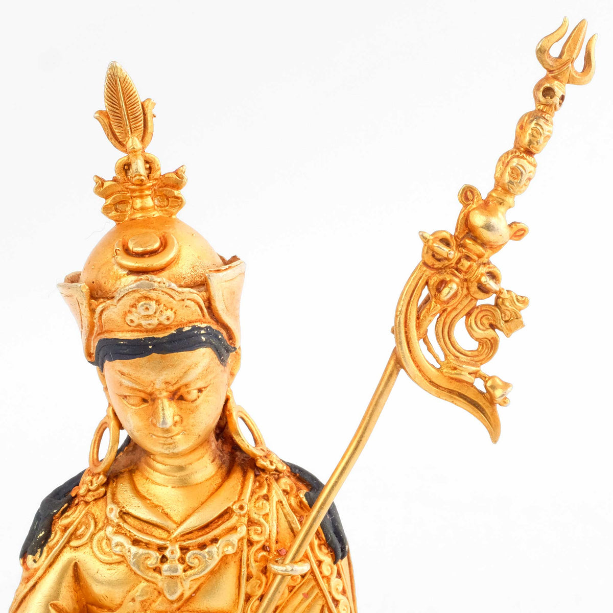 Kleine vergoldete Statue von Padmasambhava (Guru Rinpoche), an seiner linken Schulter lehnt das khatvanga. 