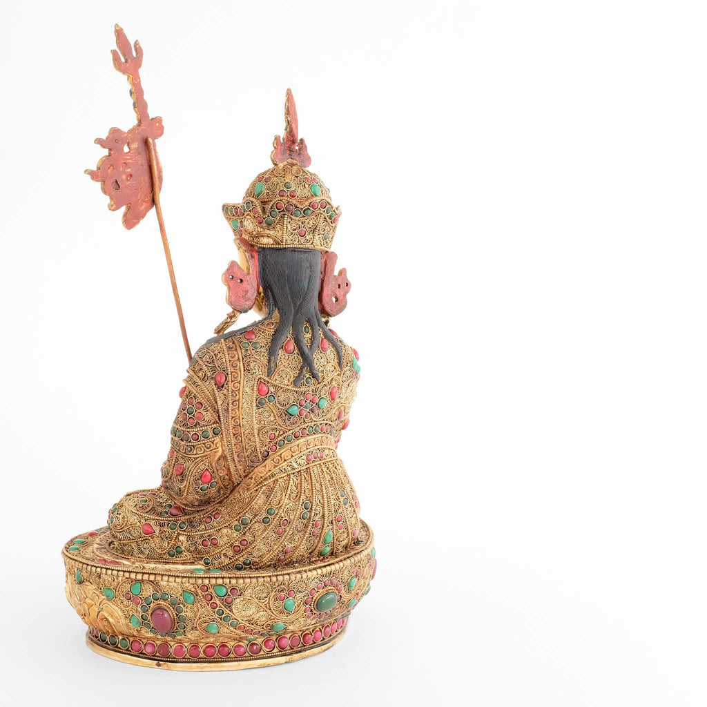 Padmasambhava, Guru Rinpoche Statue, er trägt eine königliche Robe, die mit feinen Filigran Ornamenten verziert und mit farbigen Steinen besetzt ist. Er sitzt auf einem Lotuspodest, das auf die gleiche Weise mit floralen Elementen verziert ist.