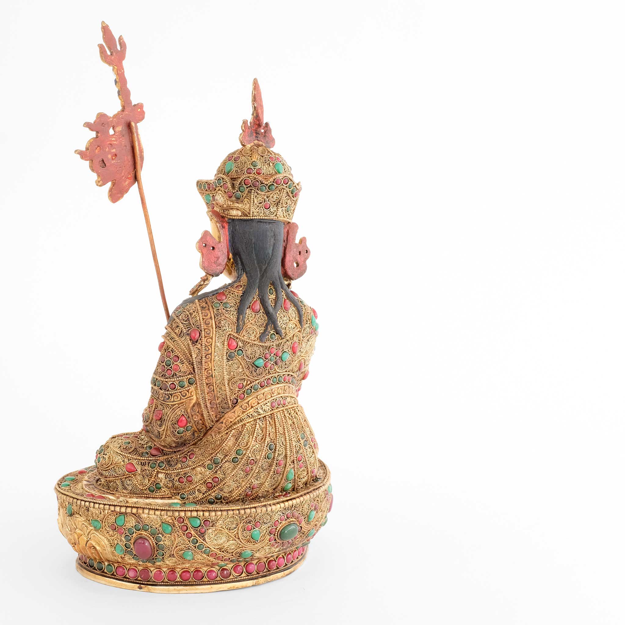 Padmasambhava, Guru Rinpoche Statue, er trägt eine königliche Robe, die mit feinen Filigran Ornamenten verziert und mit farbigen Steinen besetzt ist. Er sitzt auf einem Lotuspodest, das auf die gleiche Weise mit floralen Elementen verziert ist.