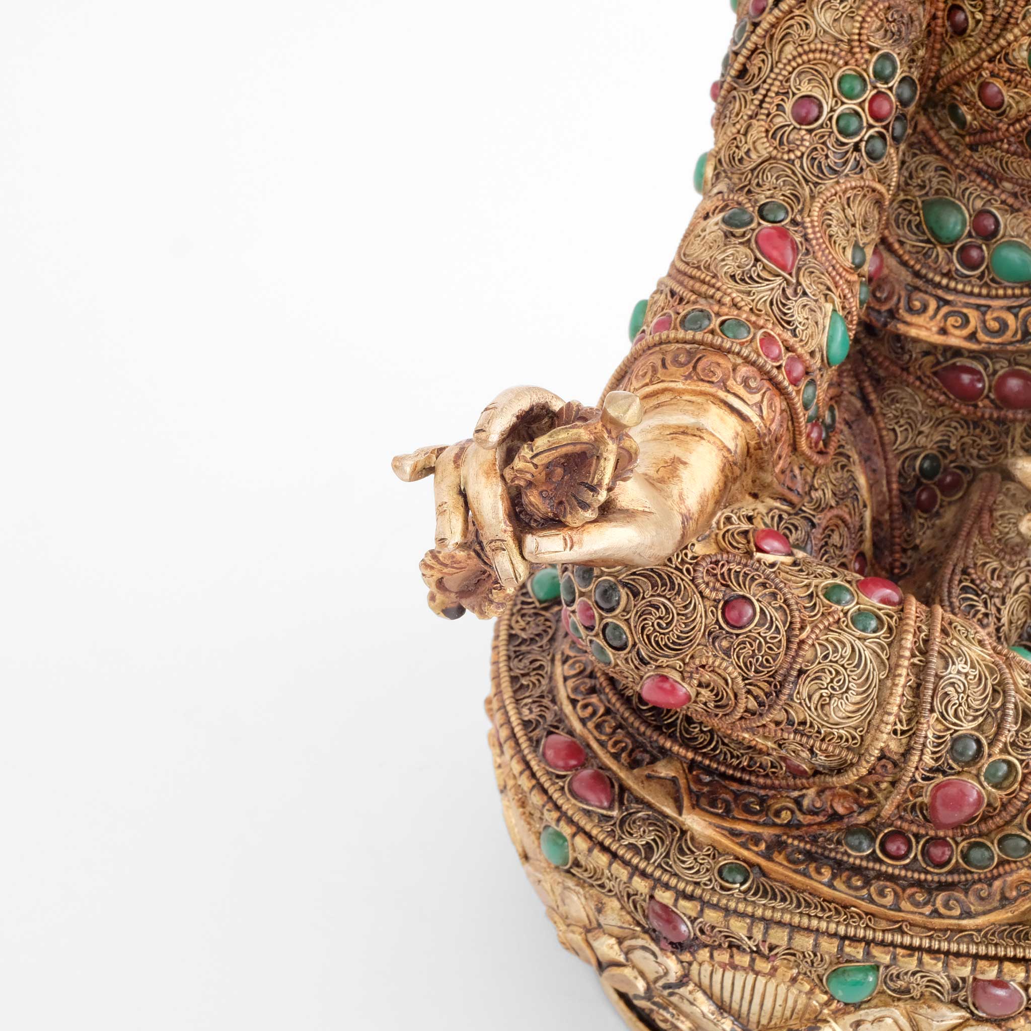 Guru Rinpoche, Padmasambhava, hält einen Vajra in seiner rechten Hand. Detail der Hand und des Filigran.