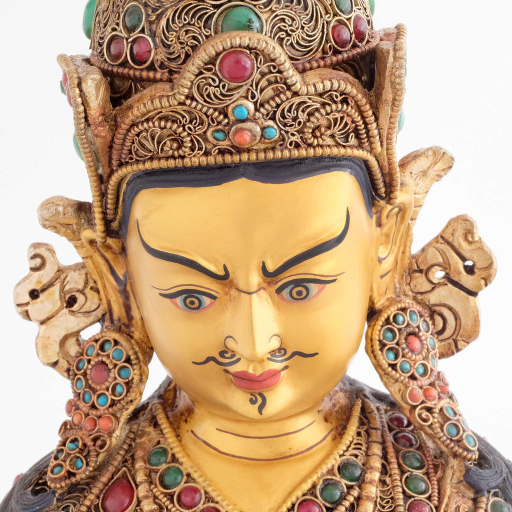 Padmasambhava Statue, das Gesicht des Guru Rinpoches ist in Gold gefasst. Er trägt einen Schnurrbart und hat vertikale Falten auf der Stirn. Das Zeichen für tiefe Gedanken.