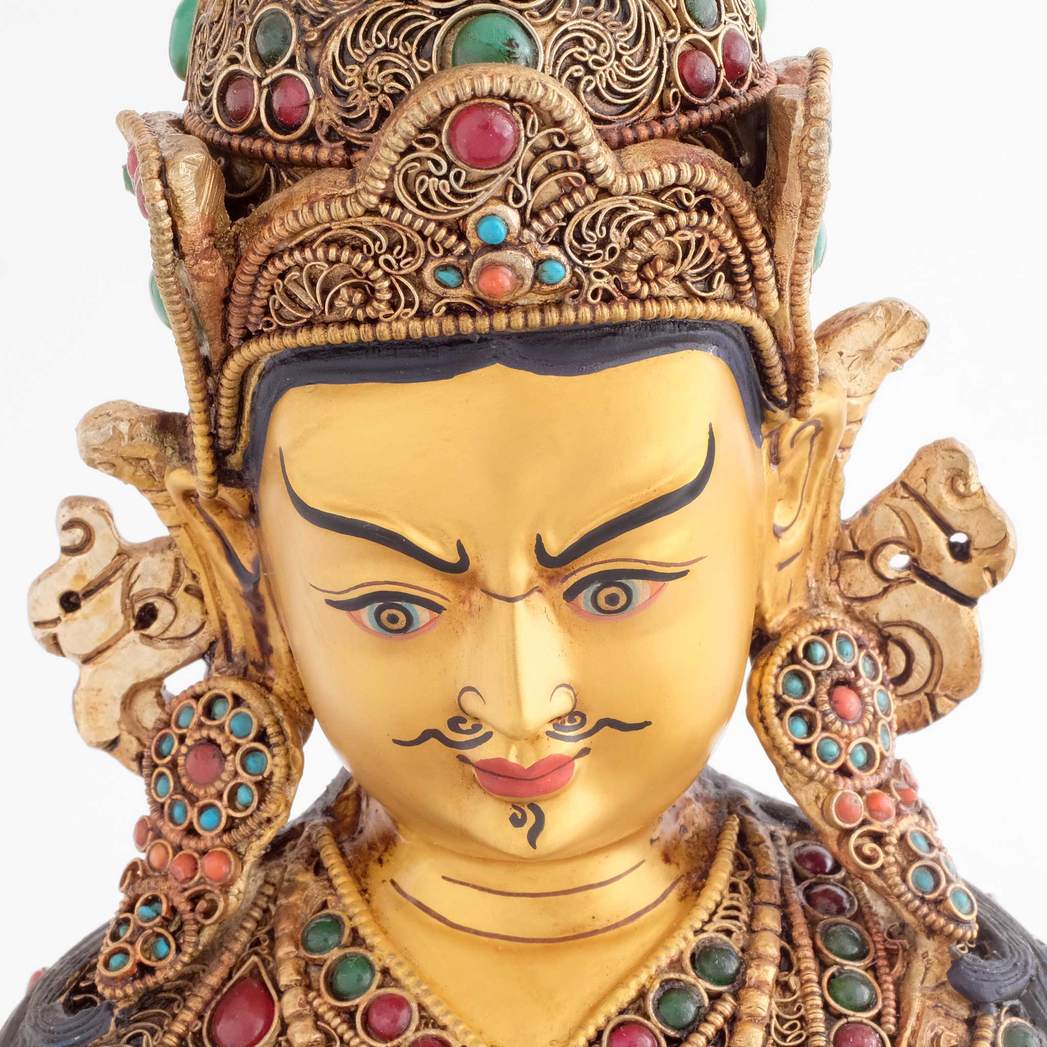 Padmasambhava Statue, das Gesicht des Guru Rinpoches ist in Gold gefasst. Er trägt einen Schnurrbart und hat vertikale Falten auf der Stirn. Das Zeichen für tiefe Gedanken.