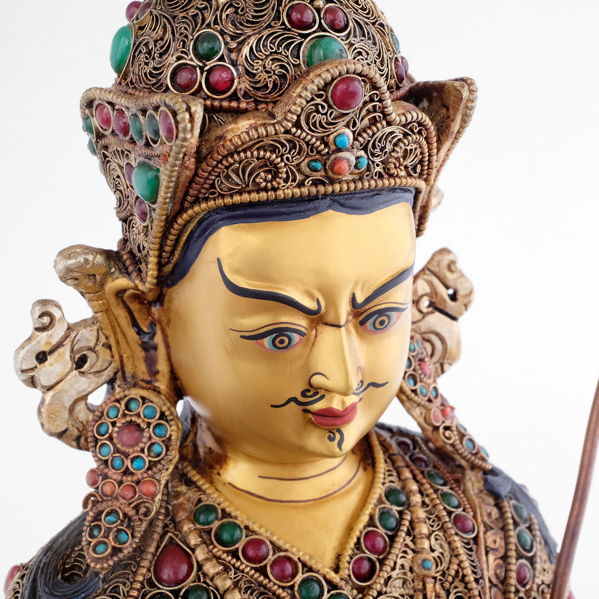 Padmasambhava Statue, das Gesicht des Guru Rinpoches ist in Gold gefasst. Er trägt einen Schnurrbart, einen kleinen Ziegenbart und hat vertikale Falten auf der Stirn. Das Zeichen für tiefe Gedanken.