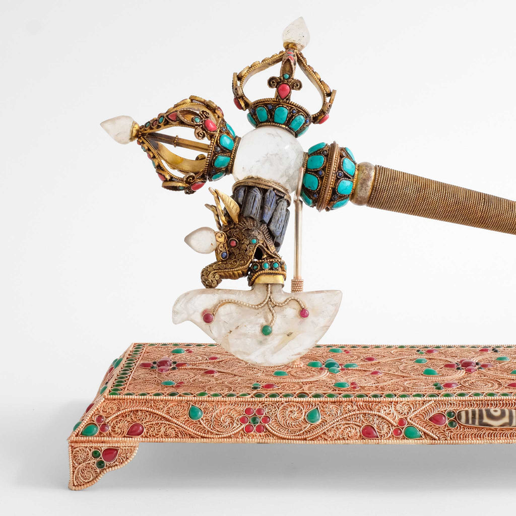 Die Klinge ähnelt der Klinge des gebogenen Messers, Kartika, der zornigen Gottheiten. Sie entspringt dem Kopf eines Seedrachens, Makara. Die Spitze und der gegenüberliegende Griff sind aus halben vajra.