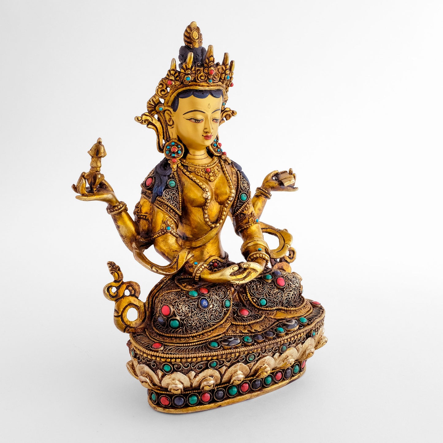 Prajnaparamita Statue, mit der Krone und dem vollen Schmuck eines Bodhisattvas. Sie hat vier Arme. In den oberen Händen hält sie ein Vajra und das Buch der Weisheit. Ihre Robe ist verziert mit feinen spiralförmigen Filigran Ornamenten.