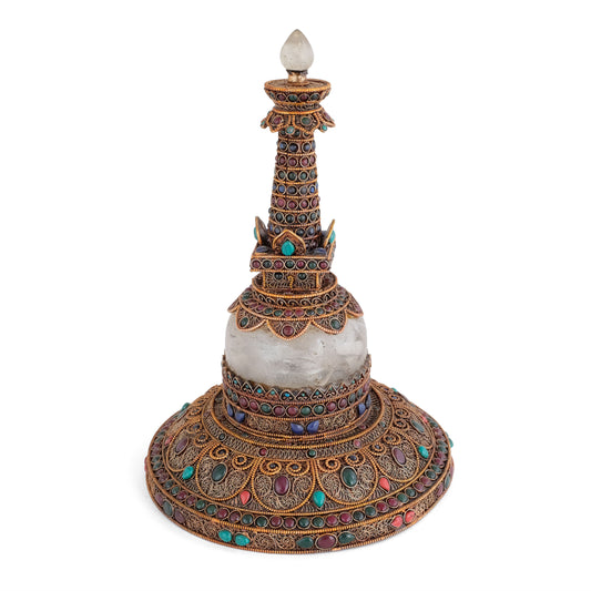 Runde Stupa aus Kupfer und Quartzkristall. Das Kupfer ist mit feinem Filigran in spiralförmigen Ornamenten besetzt, versilbert und vergoldet. Akzentuiert mit farbigen Steinen. 