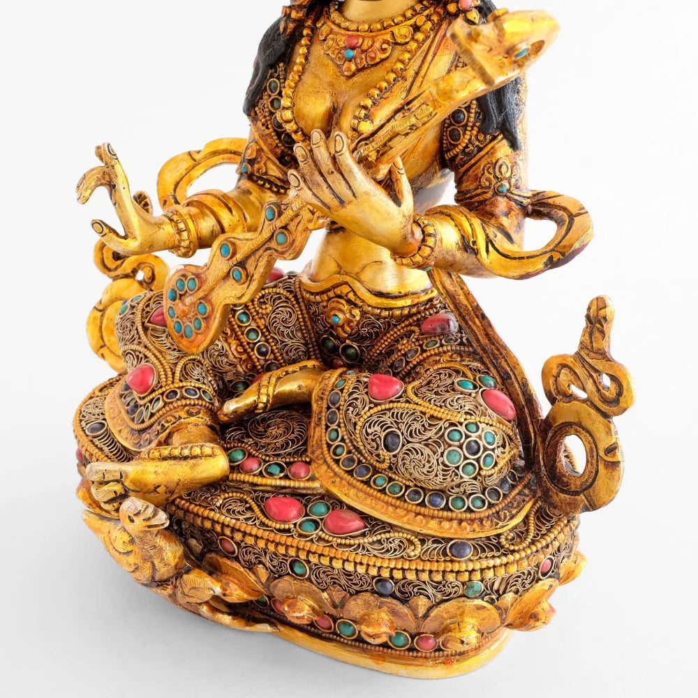 Details der Sarasvati Statue, ihre Robe und der Lotus Sockel sind mit feinem Filigran verziert und mit farbigen Steinen akzentuiert.