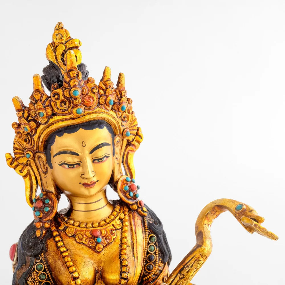Sarasvati Statue, vergoldete Kupferfigur mit Krone und vollem Schmuck eines Bodhisattva. Ihre Laute endet in einem Schwankopf der das Buch der Weisheit im Schnabel hält.