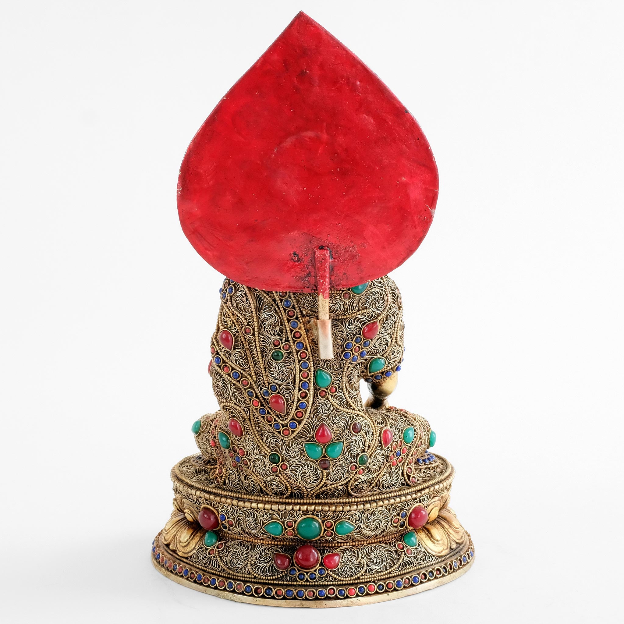 Die Shakyamuni Buddha Statue ist auch rückwärtig vollständig mit Filigran bearbeitet. Die Aureole ist auf der Rückseite rot gefasst.