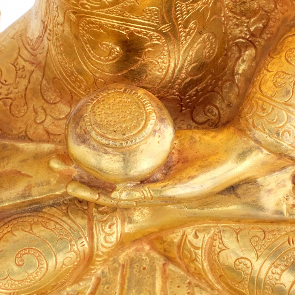 Shakyamuni Buddha, Nahaufnahme der Ziselierung und der linken Hand die eine Almosenschale hält