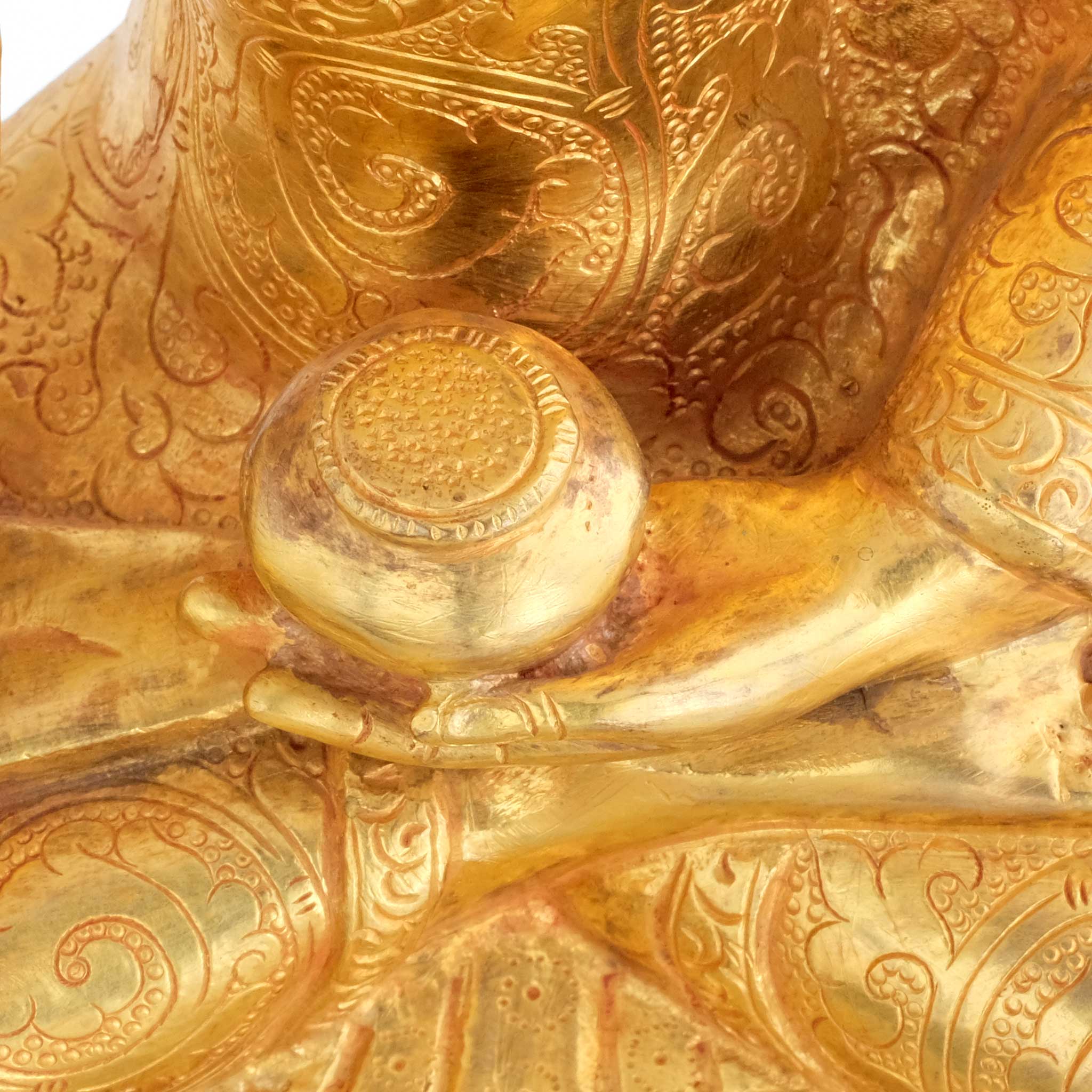 Shakyamuni Buddha, Nahaufnahme der Ziselierung und der linken Hand die eine Almosenschale hält