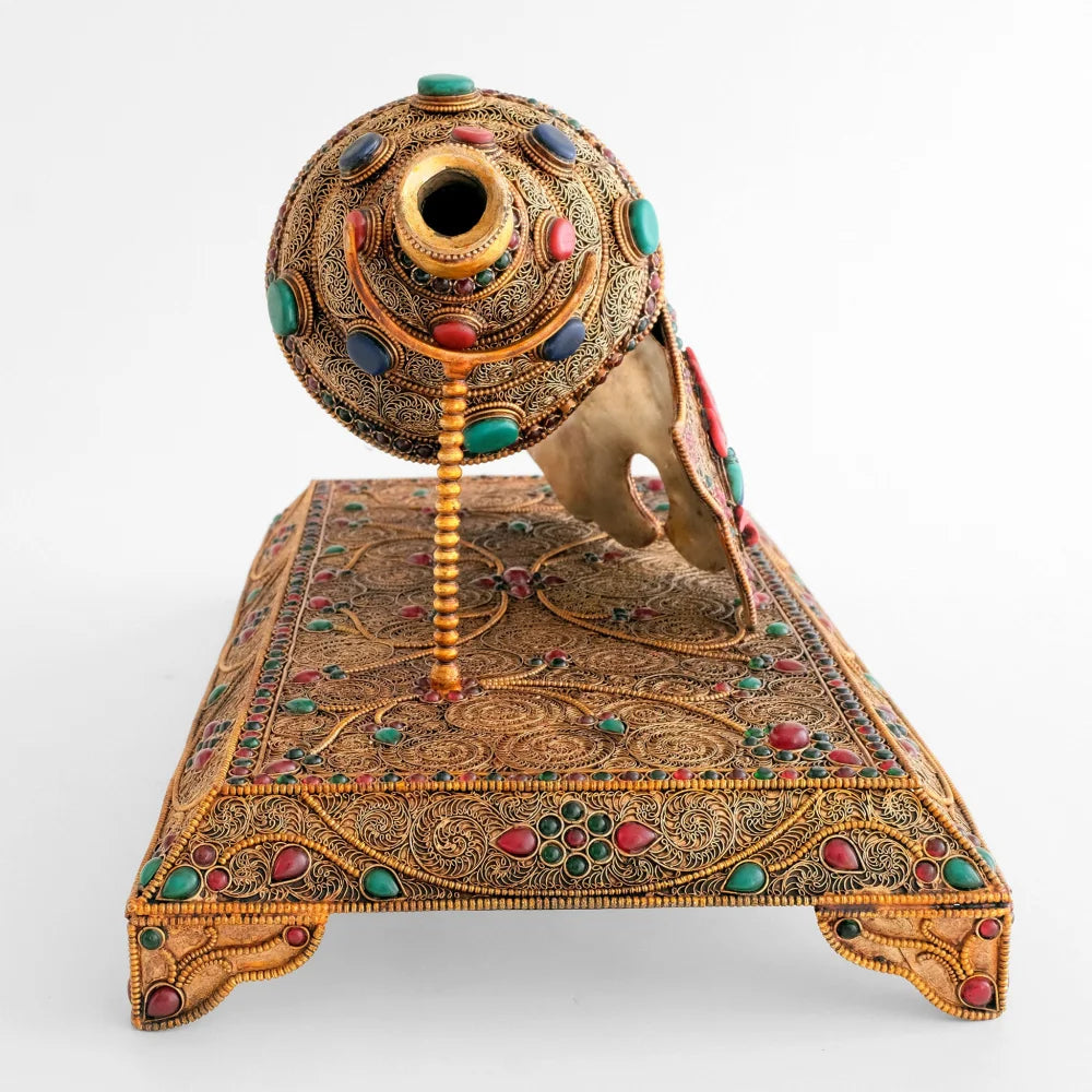 Mundstück der verzierten Shankha, Muschelhorn Trompete. Das Instrument ruht auf einem rechteckigen vierfüßigen Sockel.