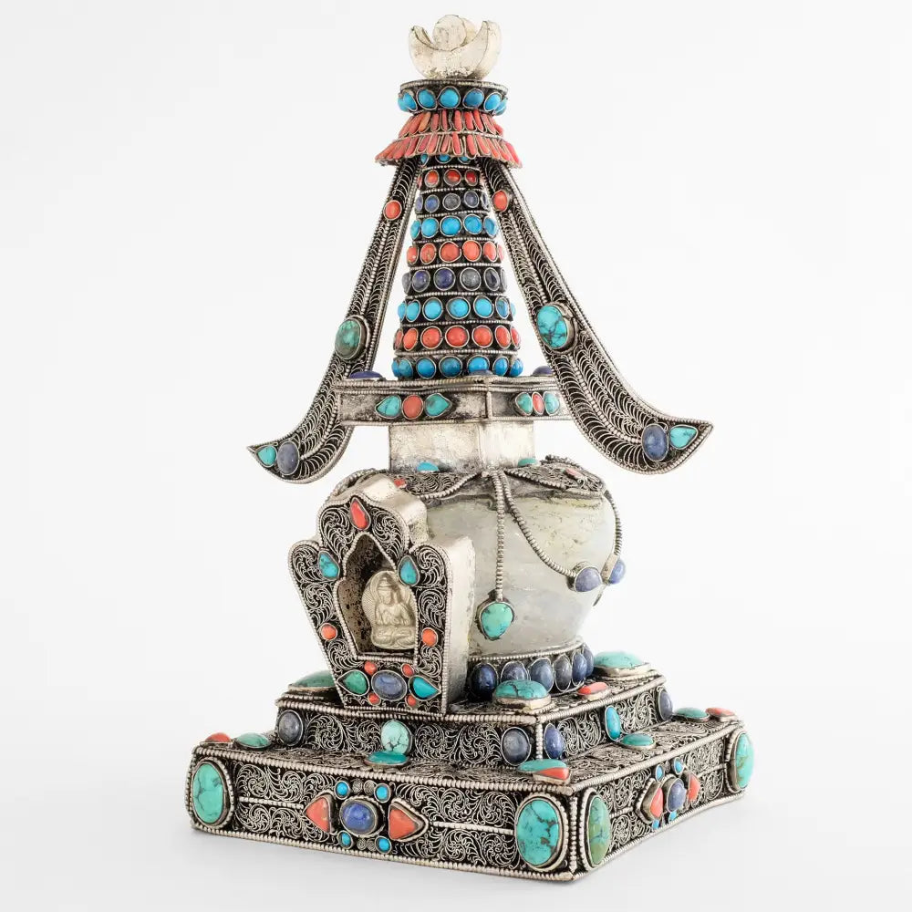Versilberte Kupfer und Kristall Stupa mit feinem Filigran verziert. Besetzt mit gefassten Koralle, Türkis und Lapis Lazuli Steinen. 
