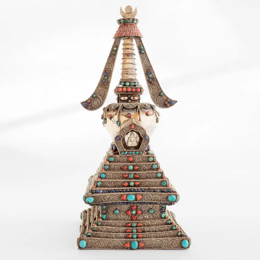 Die Stupa, die das buddhistische Universum repräsentiert, ist ein buddhistisches Heiligtum. Kupferblech und Kristall, mit Filigran verziert, versilbert, mit Türkis, Lapislazuli und Koralle besetzt. Der Kristall schenkt klare Gedanken und positive Energie. Höhe: 15" / 38 cm