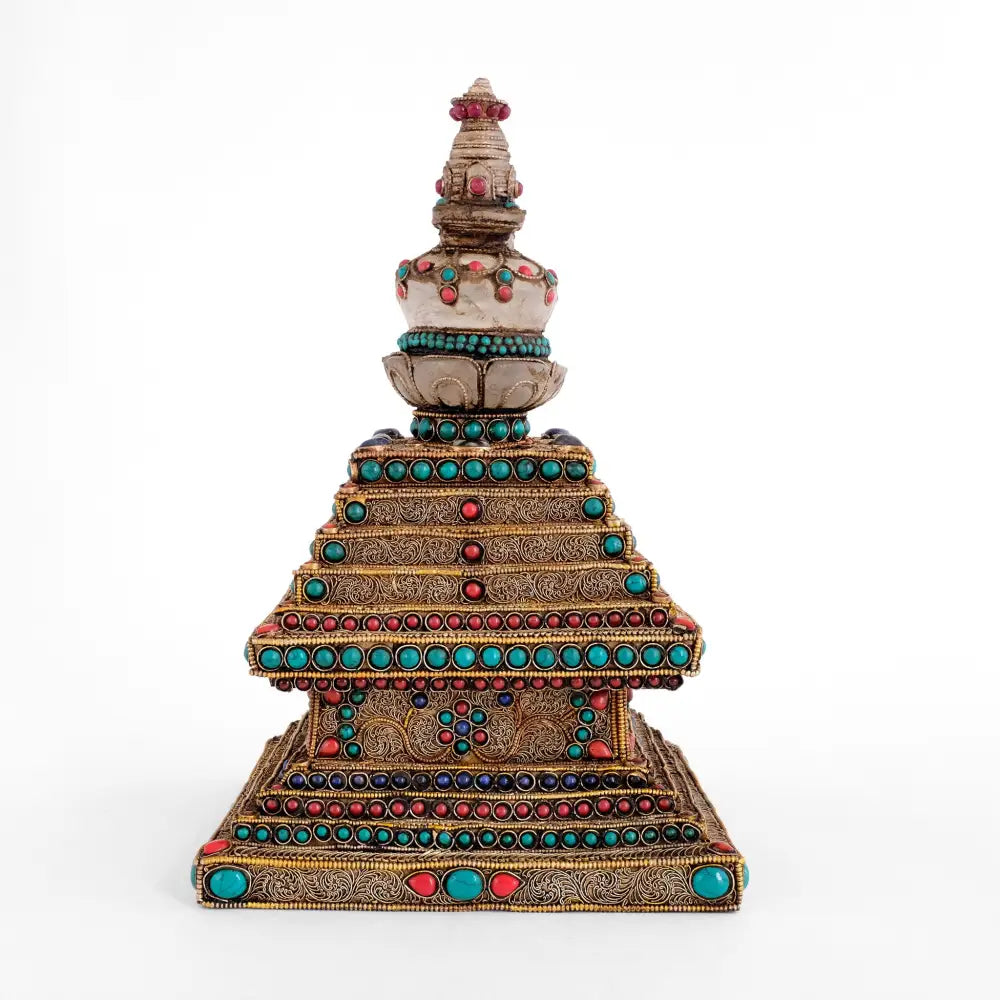 Stupa aus Kristall mit einem Kupfersockel. Das Kupfer ist mit feinen filigranen Ornamenten verziert, die mit Türkisen, Korallen und Lapislazuli-Steinen akzentuiert sind.