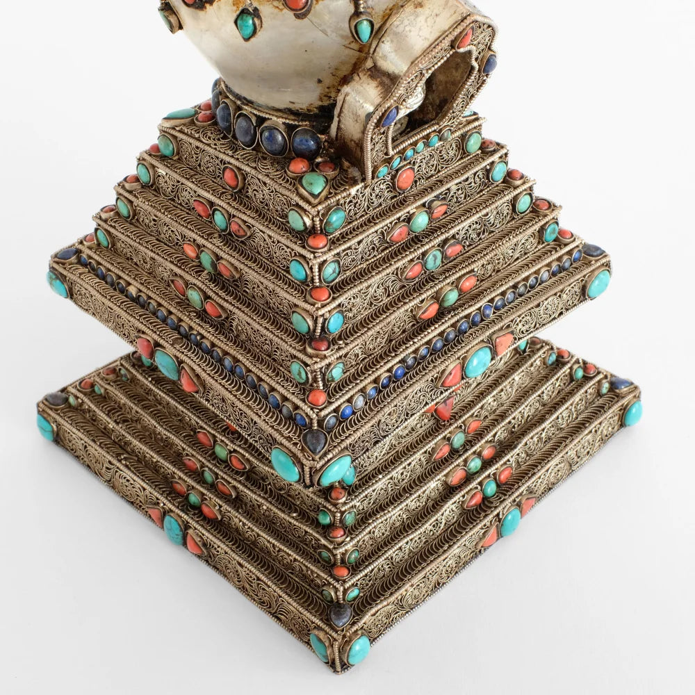 Filigran Stufa mit stufigem Sockel. Jede Stufe hat in der Mitte ein vajra Zeichen aus Türkis und Koralle. Versilbert.
