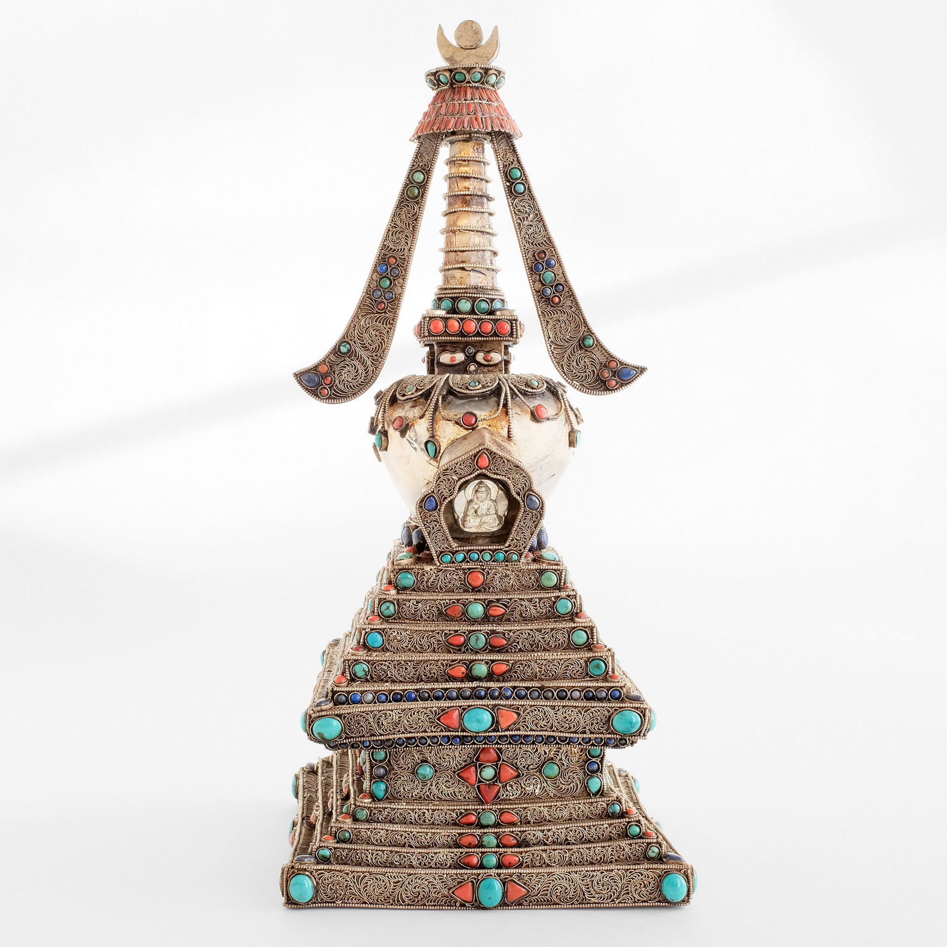 Die Stupa, die das buddhistische Universum repräsentiert, ist ein buddhistisches Heiligtum. Kupferblech und Kristall, mit Filigran verziert, versilbert, mit Türkis, Lapislazuli und Koralle besetzt. Der Kristall schenkt klare Gedanken und positive Energie. Höhe: 15" / 38 cm