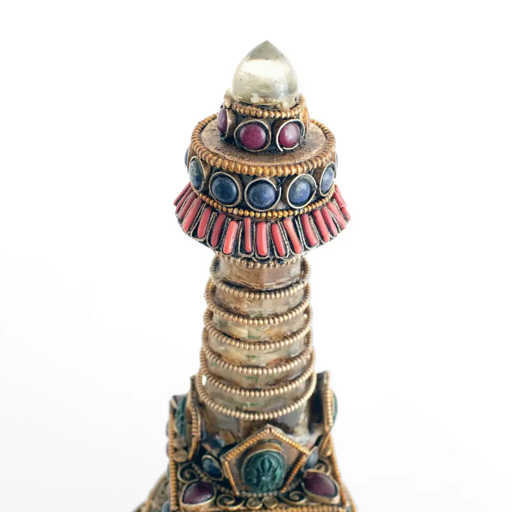 Stupa aus Kupferblech und Kristallquarz, verziert mit Filigran, versilbert und vergoldet, besetzt mit farbigen Steinen, Lapislazuli und Koralle. Aufgesetzte kleine Vajra geprägte Votivtafeln. Kristallspitze.