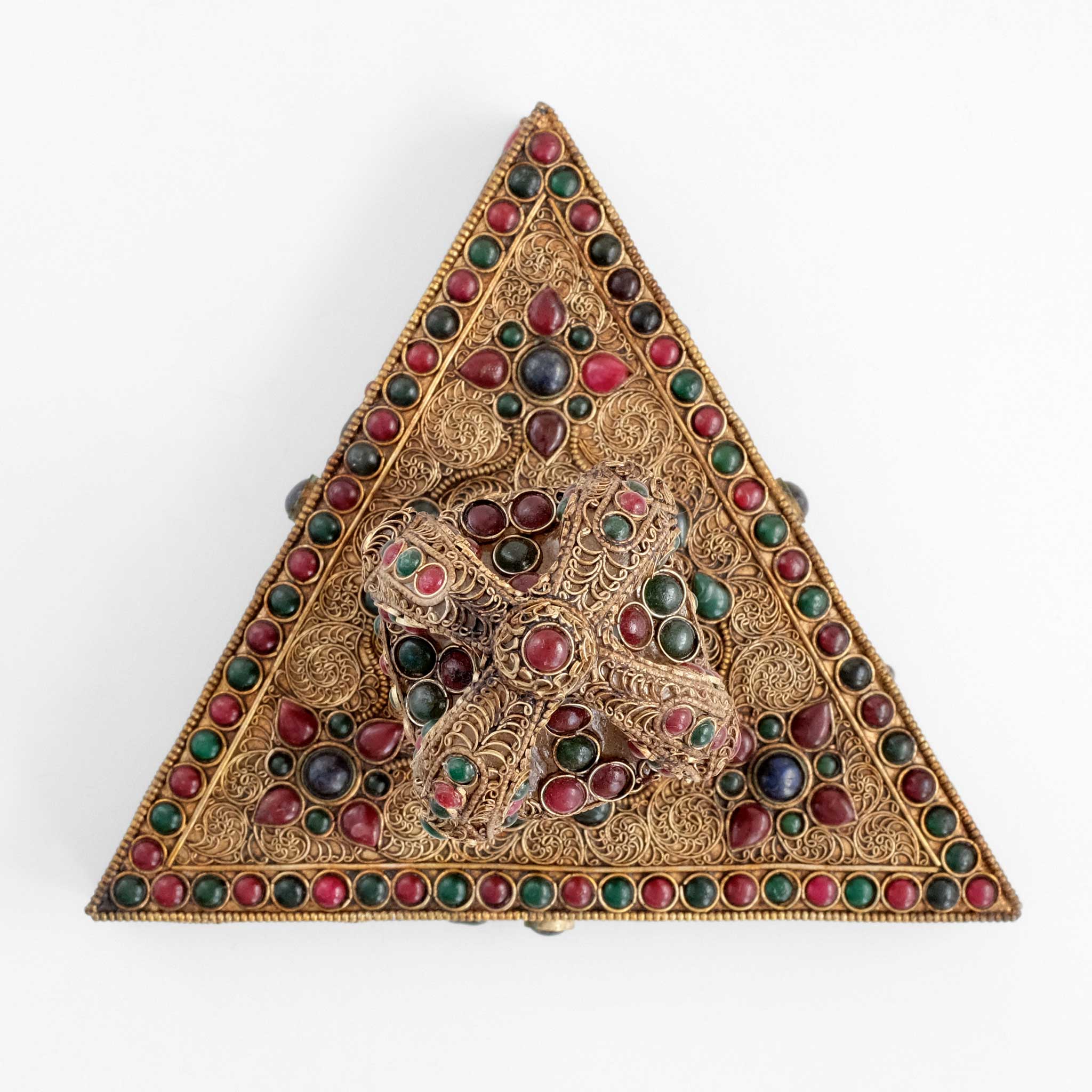 Kristall vajra auf dreieckigem Sockel von oben gesehen. Vajra und Sockel sind mit Filigran bearbeitet.