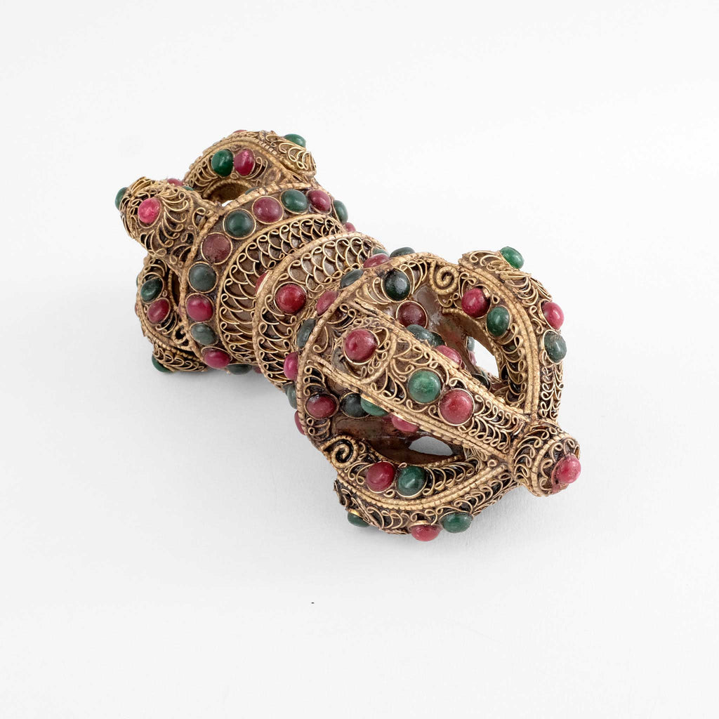 Mit vesilbertem Filigran verzierter Kristall Vajra mit roten und grünen Steinen.