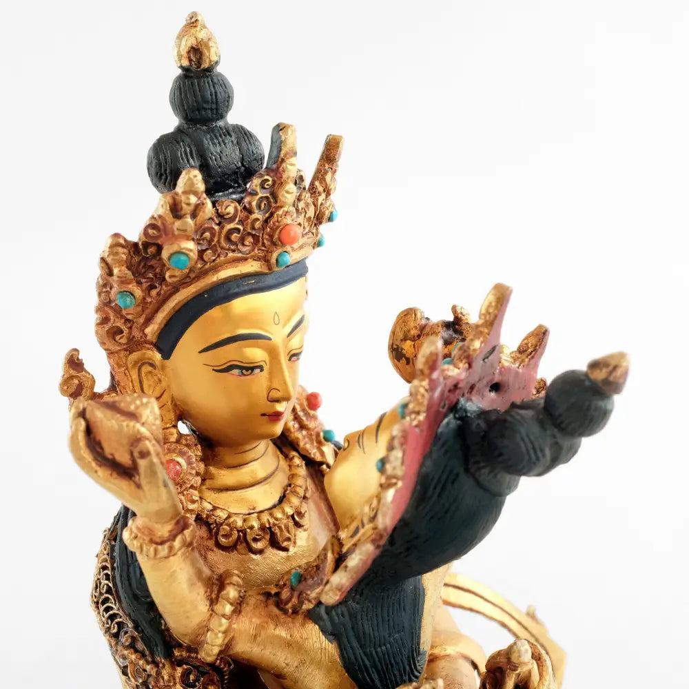 Vajradhara schaut seine Gemahlin an. Sie hält einen Kapala in der linken Hand, eine Kartika in der rechten Hand. Der Adibuddha hält eine Glocke, Ghanta, in seiner linken Hand und einen Vajra in seiner rechten Hand.