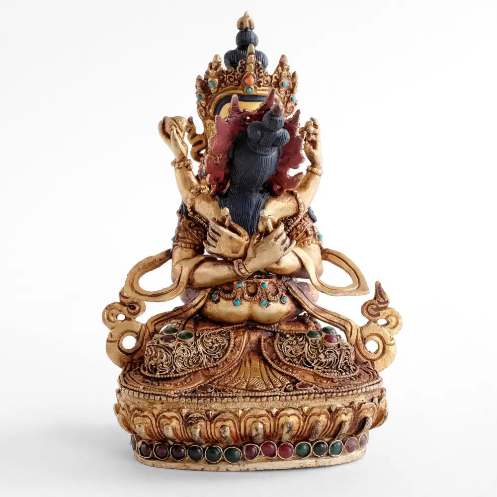 Vajradhara mit seiner Gefährtin in Yab Yum. Seine Hände sind hinter ihrem Rücken in Vajrahunkara Mudra gekreuzt. Die goldene Adi Buddha Figur ist mit feinen Filigran Ornamenten verziert und mit farbigen Steinen besetzt.