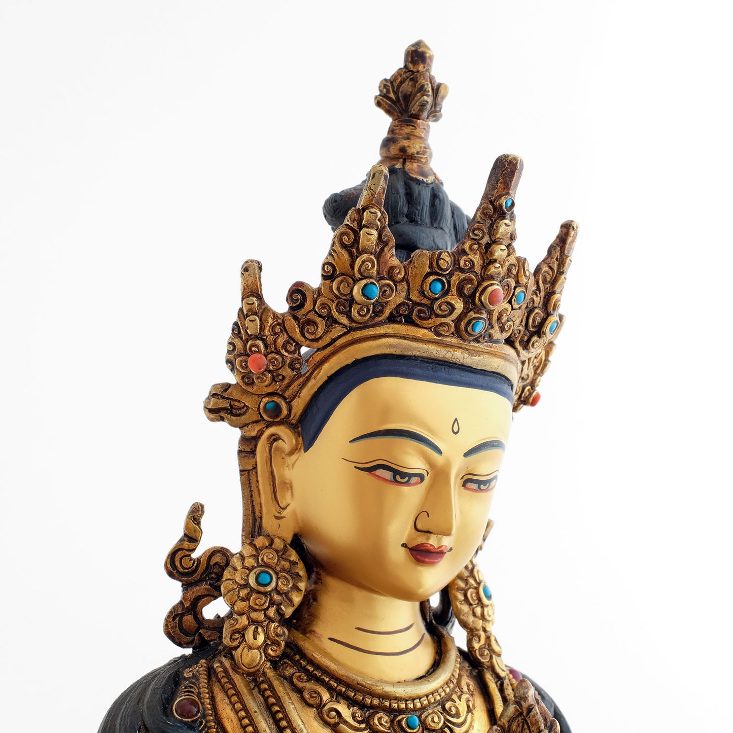 Das feine entspannte Gesicht der Vajrasattva Statue. In Gold gefasst. Mit türkisfarbenen und korallfarbenen Steinen akzentuiert. Die Spitze des Ushnisha ist ein Halb-Vajra.