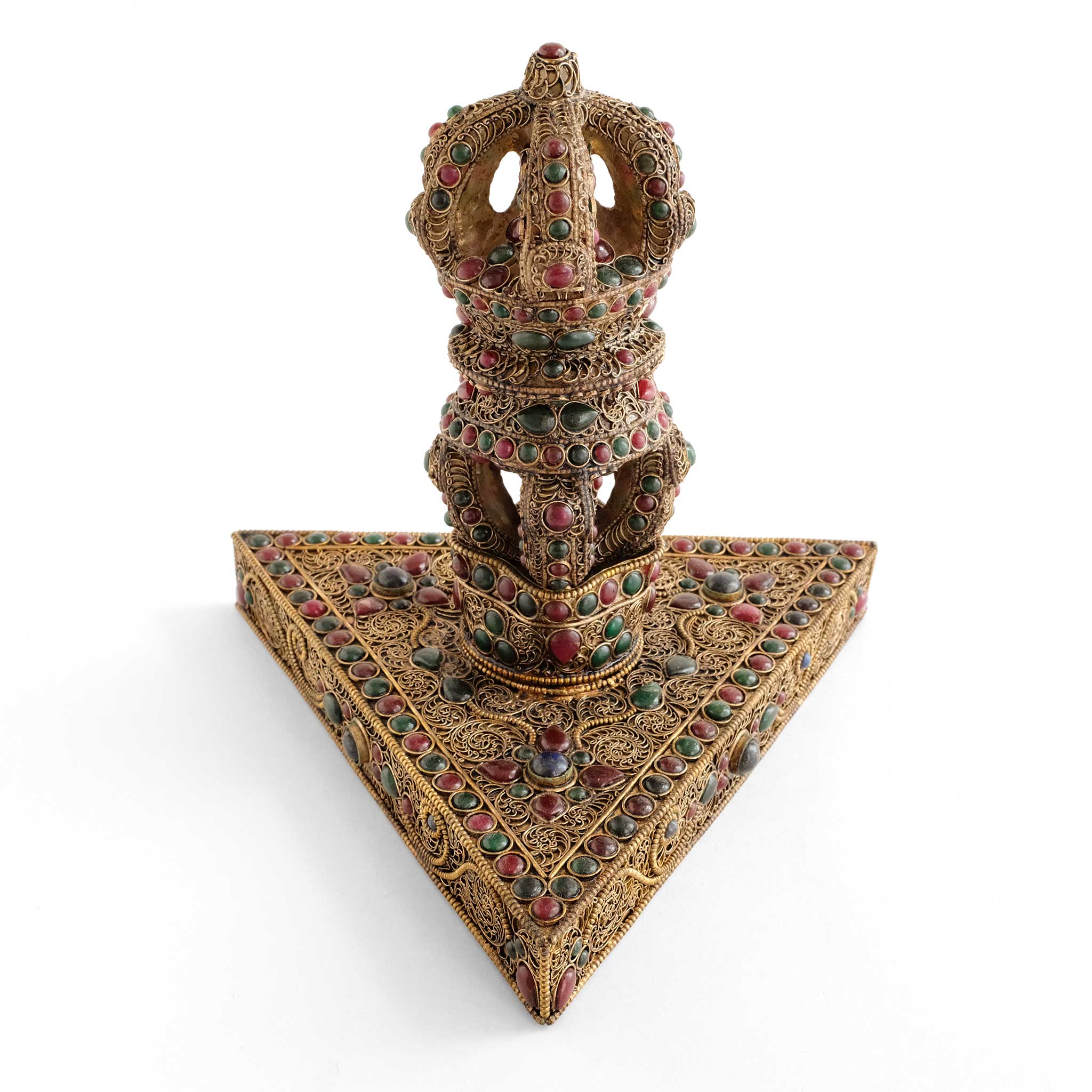 Kristall vajra aufrecht auf einem dreieckigen Sockel. Das vajra und der Sockel sind mit Filigran verziert und farbigen Steinen.