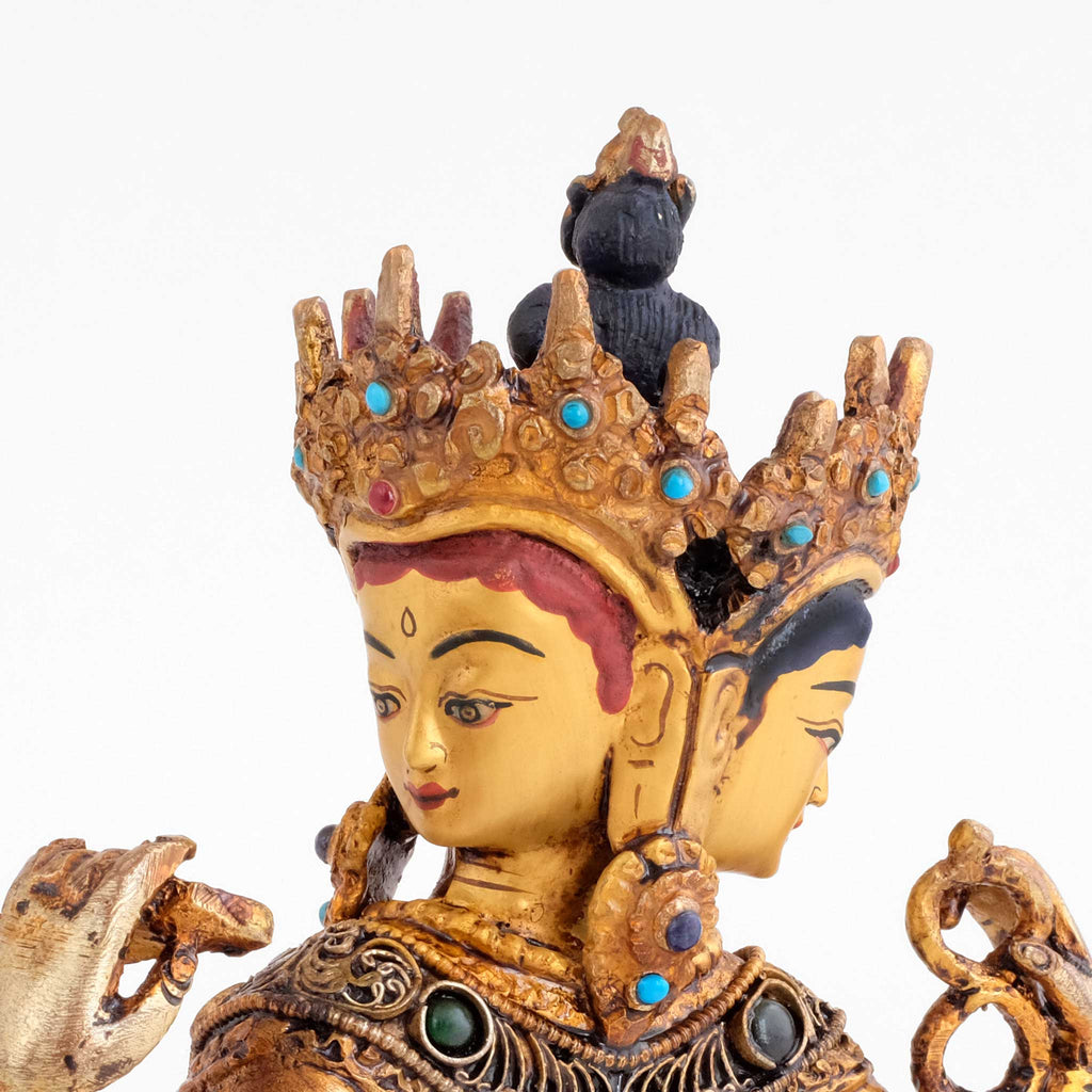 Vasudhara statue, Detailaufnahme von zwei ihrer drei Gesichter. Mit Krone und  vollem Schmuck eines Bodhisattva. Die vordere Hand hält das Buch der Weisheit, die hintere eine Mala.
