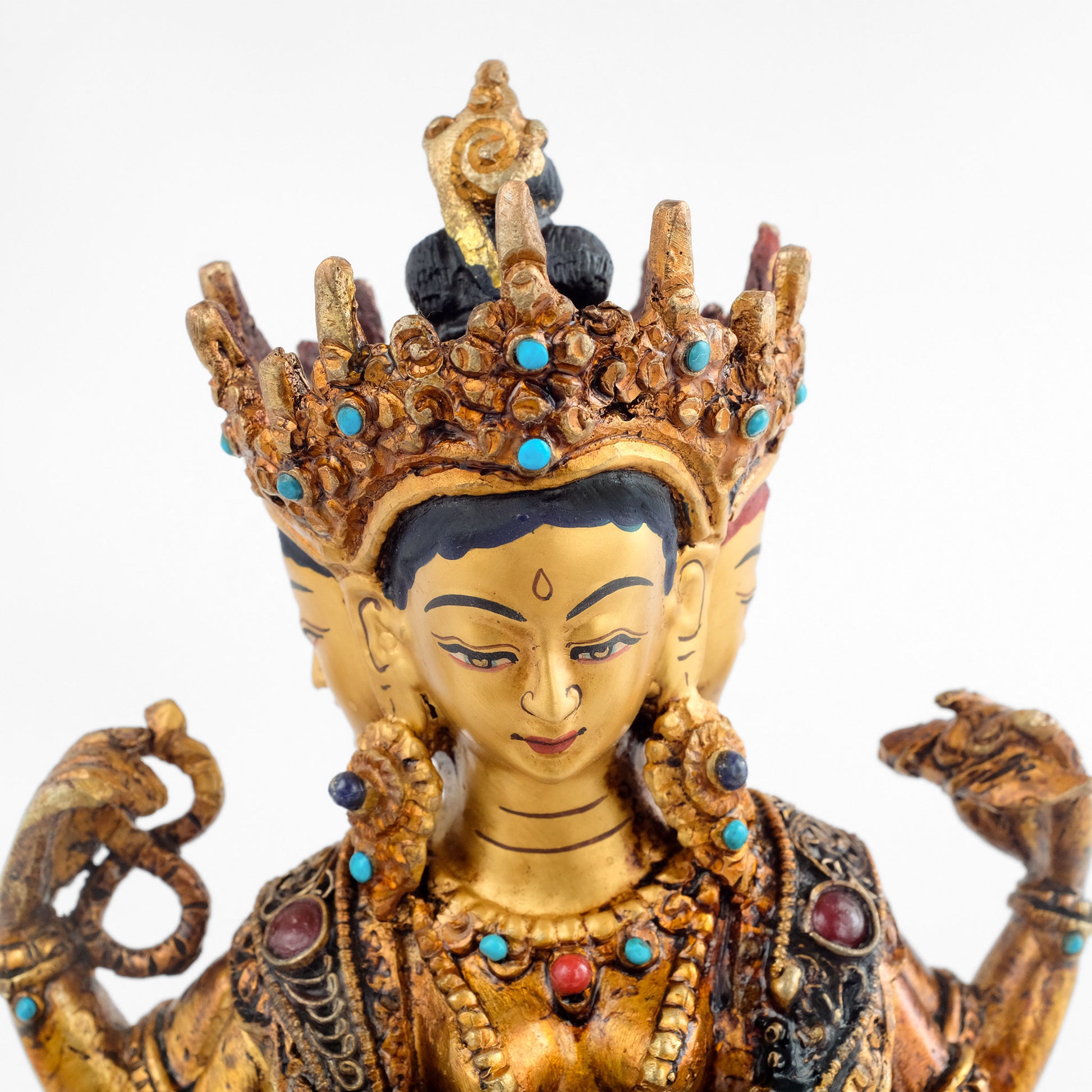 Vasudhara statue, Detailaufnahme von ihren drei Gesichtern. In ihrer rechten Hand hält sie einen Rosenkranz, in der linken Hand das Buch der Weisheit, die Prajnaparamita.