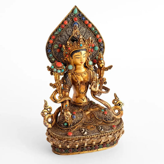 Weiße Tara Statue, aus Kupfer gegossener Körper, Wachsausschmelztechnik, verziert mit feiner Filigran Ornamentik, versilbert und vergoldet, besetzt mit Türkis, Koralle und Lapislazuli. Im Sockel künstliche Steine in Rubinrot und Smaragdgrün. Das Gesicht ist in Gold gefasst.