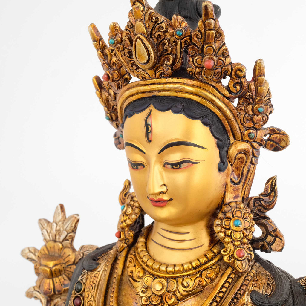 Weiße Tara Statue, Detailaufnahme von Gesicht, Krone und Schmuck. Sie trägt ein drittes Auge auf der Stirn.