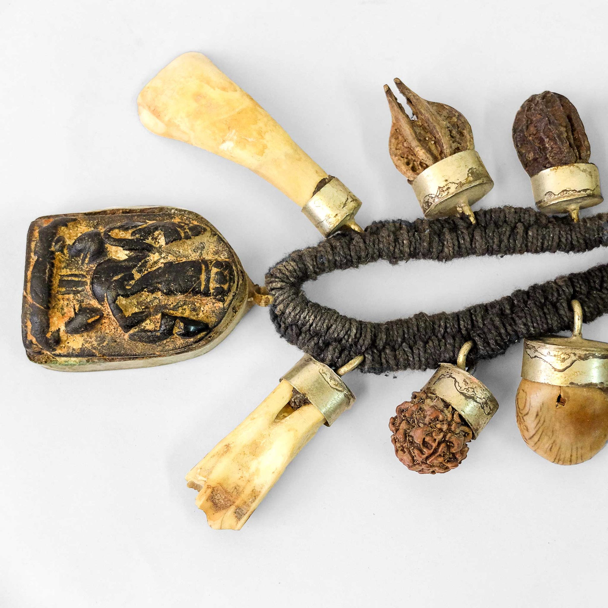 Tantrische Schutzmala mit Amulett, Knochen, Zähnen und getrockneten Beeren.