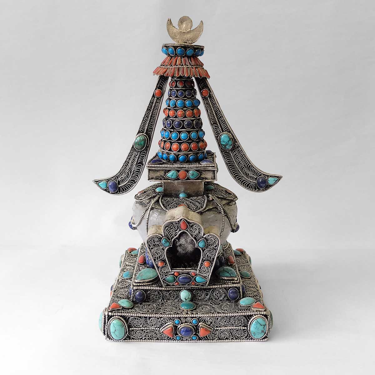 Stupa aus Kupfer, mit Filigran verziert, versilbert, mit Türkis, Koralle und Lapislazuli besetzt. Die Kuppel ist aus Kristall. 